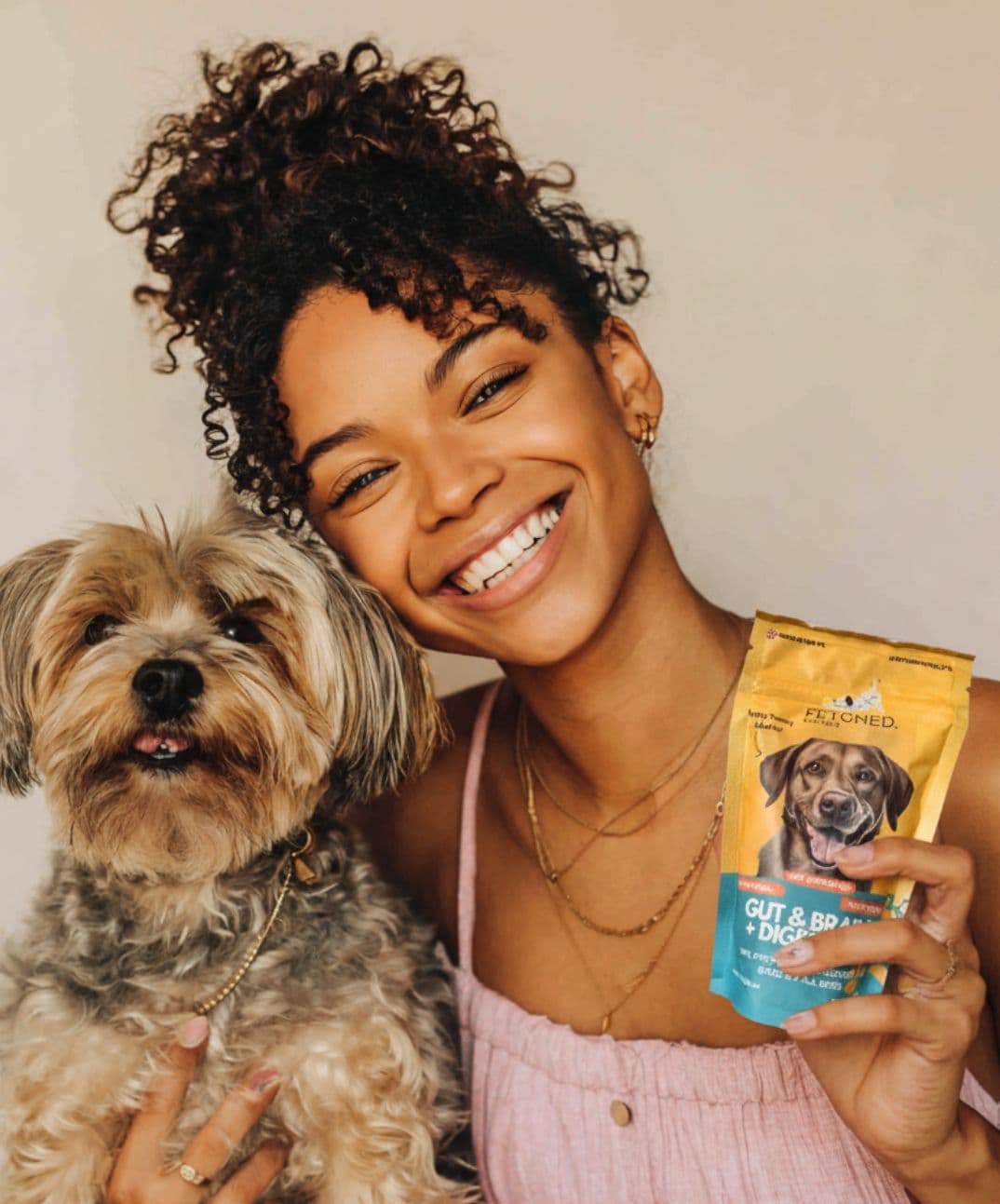 Happy dog owner holding Fetched probiotic pouch alongside her pooch